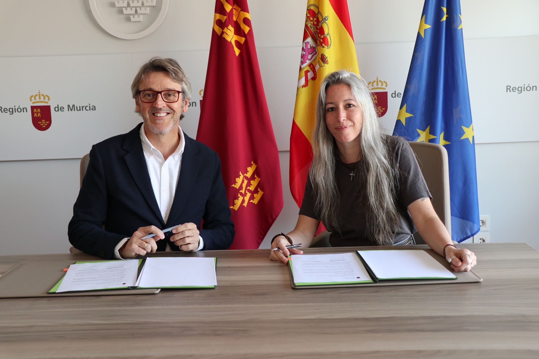 Imagen de la firma del convenio 'Funcionarios Solidarios' con Ángela Cas, presidenta de Qué Pupilas, y Luis Alberto Marín González, consejero de Hacienda en 2025.